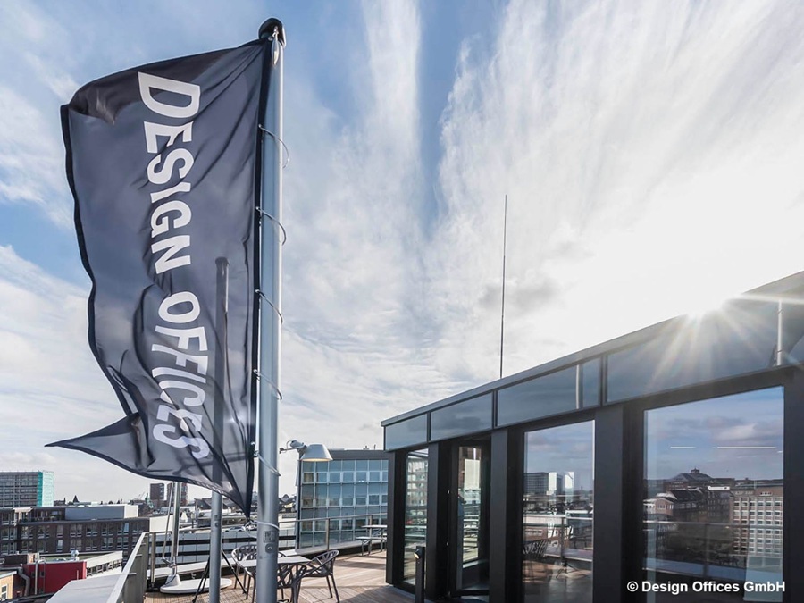 Panoramablick auf die Dachterrasse der Design Offices in Hamburg mit moderner Glasfassade und Stadtblick bei Sonnenschein.