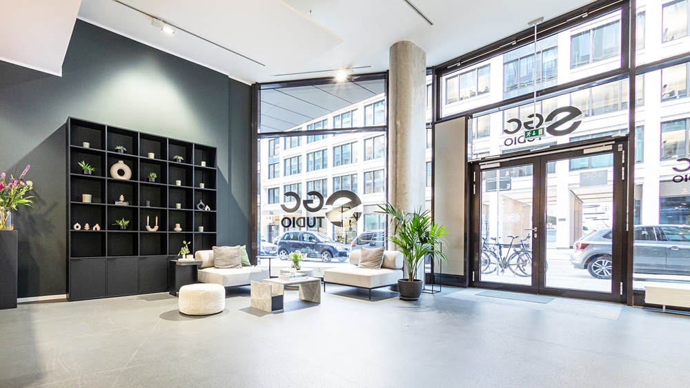 Lichtdurchfluteter Showroom mit modernen Sitzmöbeln, Designregal und urbanem Blick in zentraler Lage von Hamburg-Neustadt.